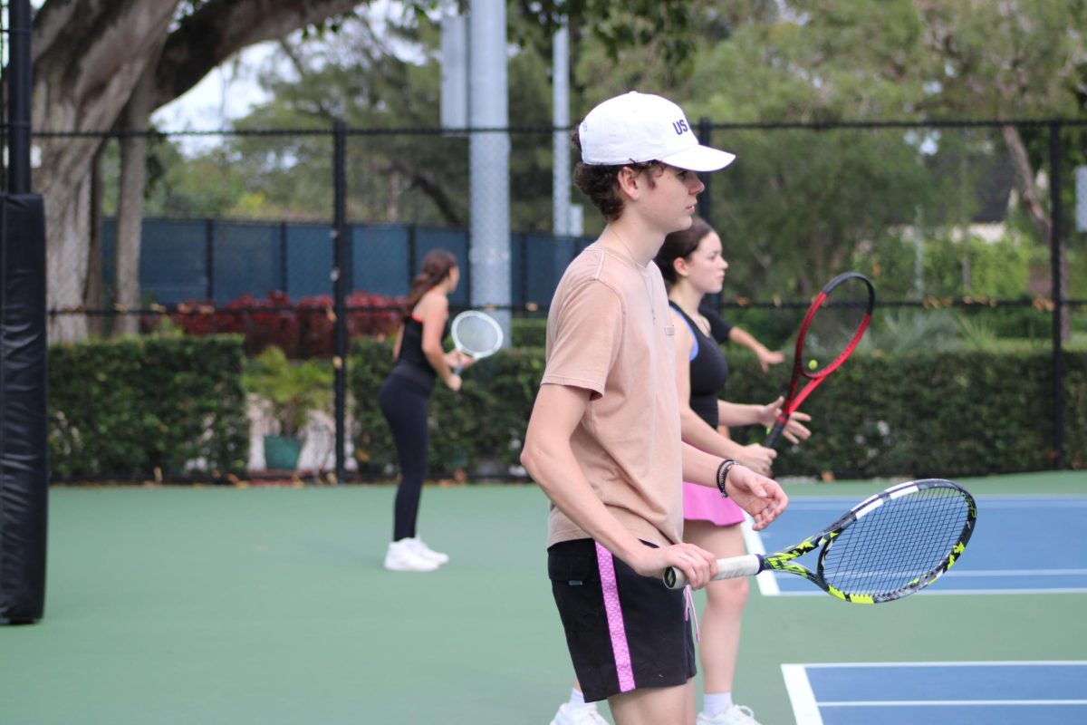 Tennis players attempting to join the Gables team, line up to display their skills at tryouts. 