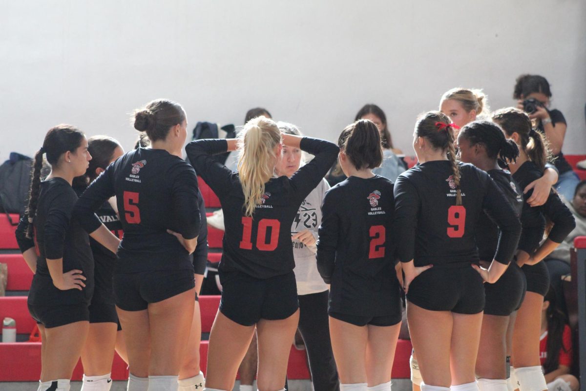 The varsity Lady Cavs getting a pep talk at the end of the second set.