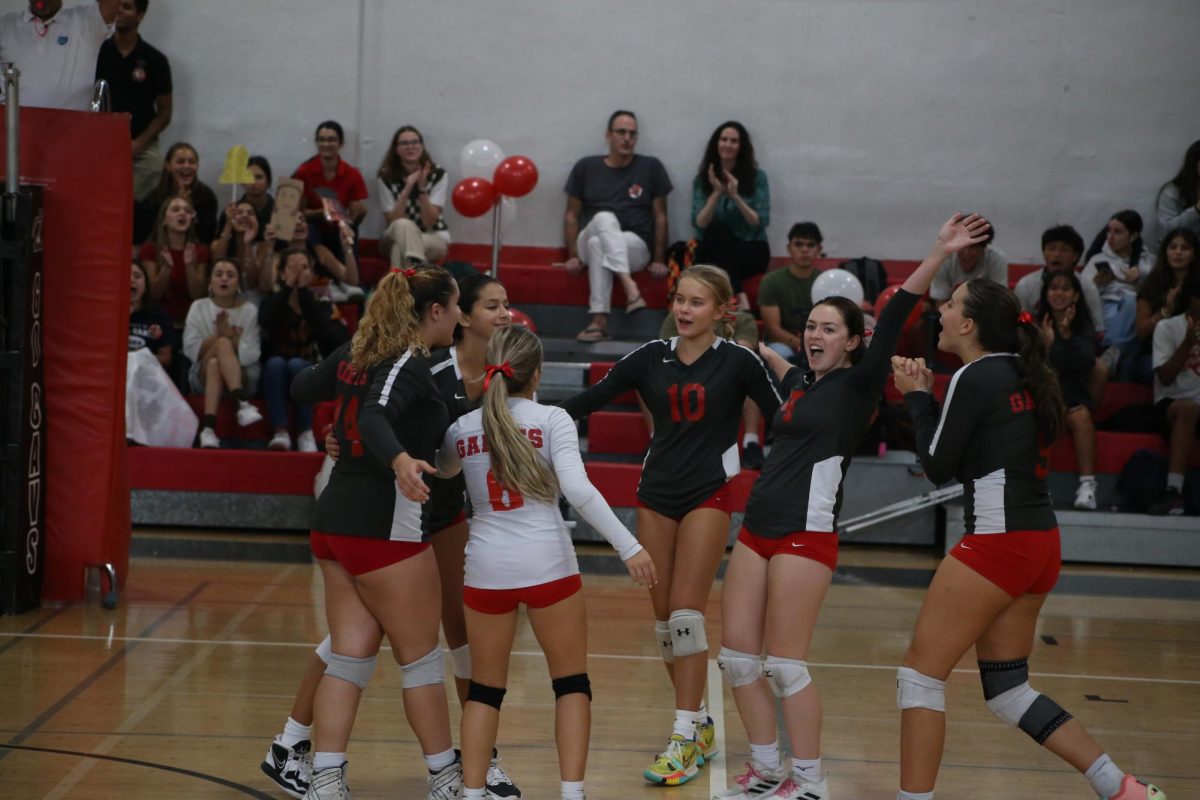 Rejoicing with her teammates, Benson (sixth to the right) celebrates a point during Senior night.