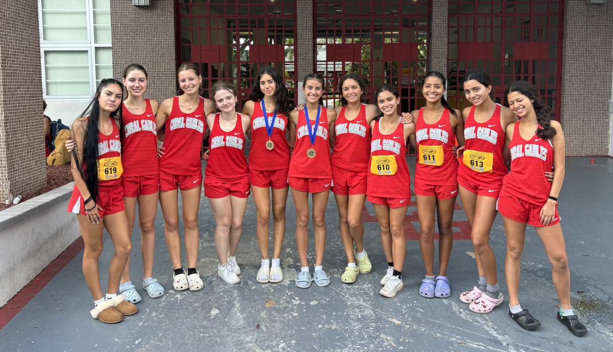 The girls cross country pose in front of the school after a long day. Most of them ran personal records at the race.