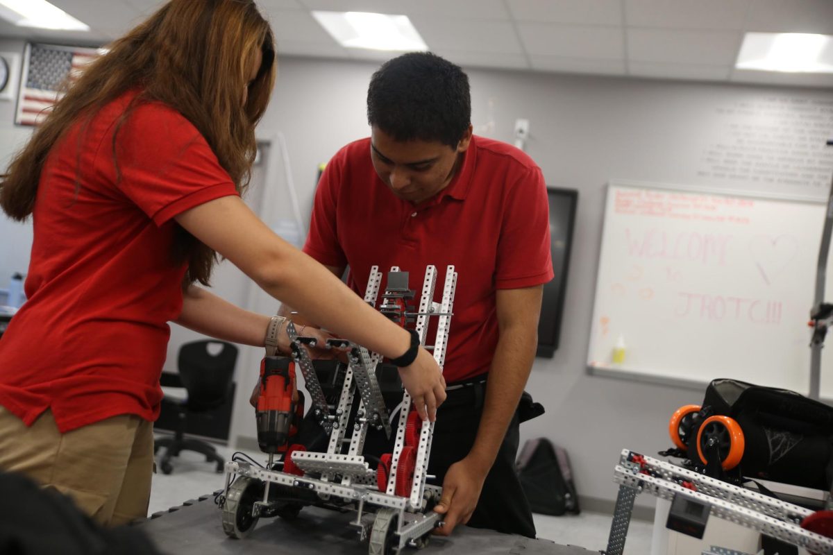 JROTC students continue building their robots in preparation for their first meet. The second part of the robot is fully attached to the motor base and it awaits completion. 