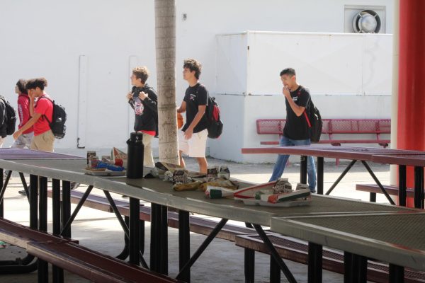 Scraps having been left been, students walk by the pavilion casually unaware of those who would later leave their tables spotless.