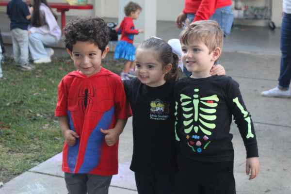 Preschoolers show off their Halloween costumes and relish in their friendship. 