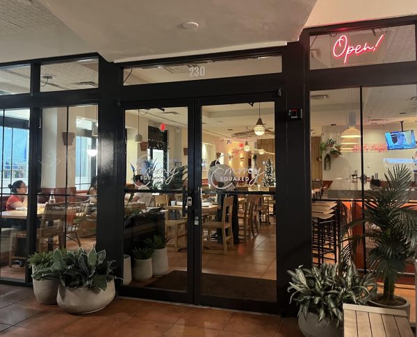 Glancing through the doors of Emmy's Squared Pizza, prospective diners are enticed by the possibility of a great pizza. The inviting and decorated atmosphere further draws them in. 