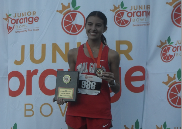 Junior Avril Donner poses with her plaque and medal after winning first place at the Junior Orange Bowl Meet. 