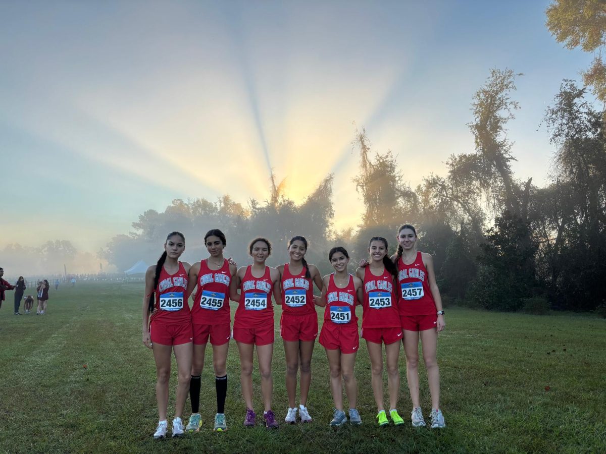 Waiting in anticipation, the girls cross country team posed before their big race, nervous to start sweating through their chilly morning run.