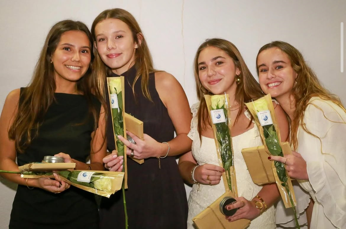 Juniors gather to take a picture, showing off their flowers and IB pins, symbolizing all of the hard work they have put in the past two years.