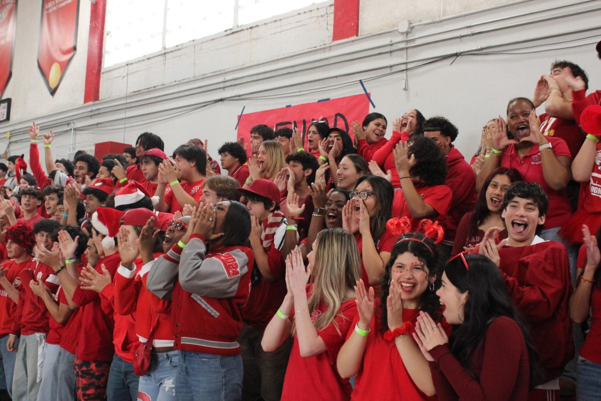 As the pep rally begins, the seniors come together to create a red section in the gym. Laughing and cheering, they are excited for the games and performances that awaits them.