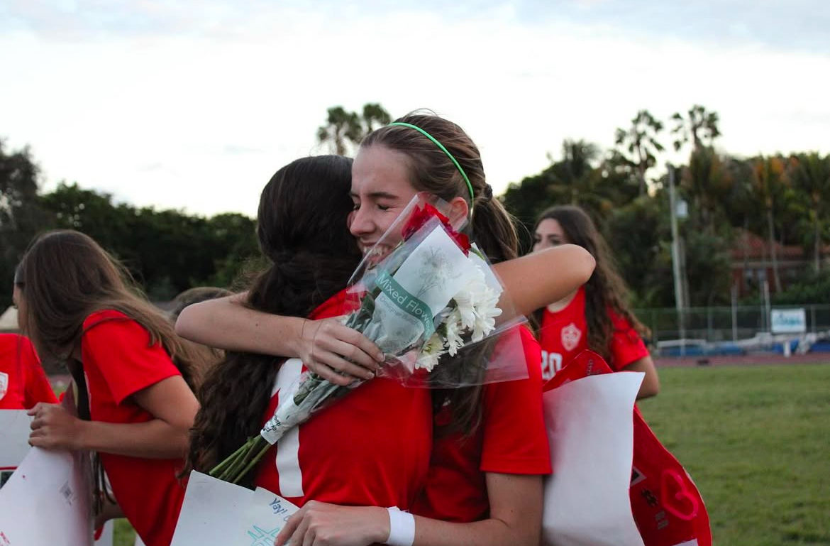 Senior Ainoa Grisar hugs her fellow teammates, thanking them for the gifts she received on her Senior Night game. She shows gratitude to everyone for the amazing four years she has had on the team.